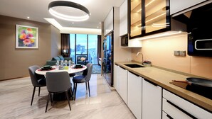 Una cocina moderna con microondas integrado, un lavamanos y una zona de comedor con una mesa redonda y sillas.