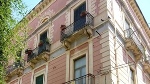 Un immeuble à plusieurs étages doté de balcons, d’une antenne parabolique et d’un panneau indiquant « accès interdit ».