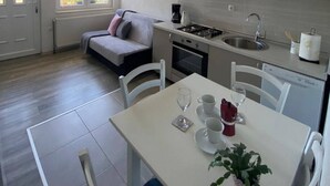 Una cocina compacta con comedor, sofá y vistas al exterior.