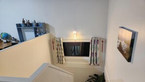 Een trap met een raam, een wereldbol en een plank met decoratieve spullen.