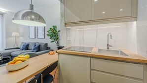 A modern kitchen with a wooden countertop, a stainless steel sink, and a built-in oven.
