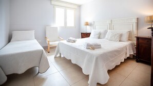 A hotel room with two single beds, a large window, a wooden chair, and a nightstand with a lamp. - Villa Luna 20 meters from the sea in Punta Prosciutto (Punta Prosciutto)