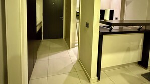A modern kitchen with a stainless steel range hood, a black countertop, and a tiled floor. - TQ Plaza 314 Suite (Budva)