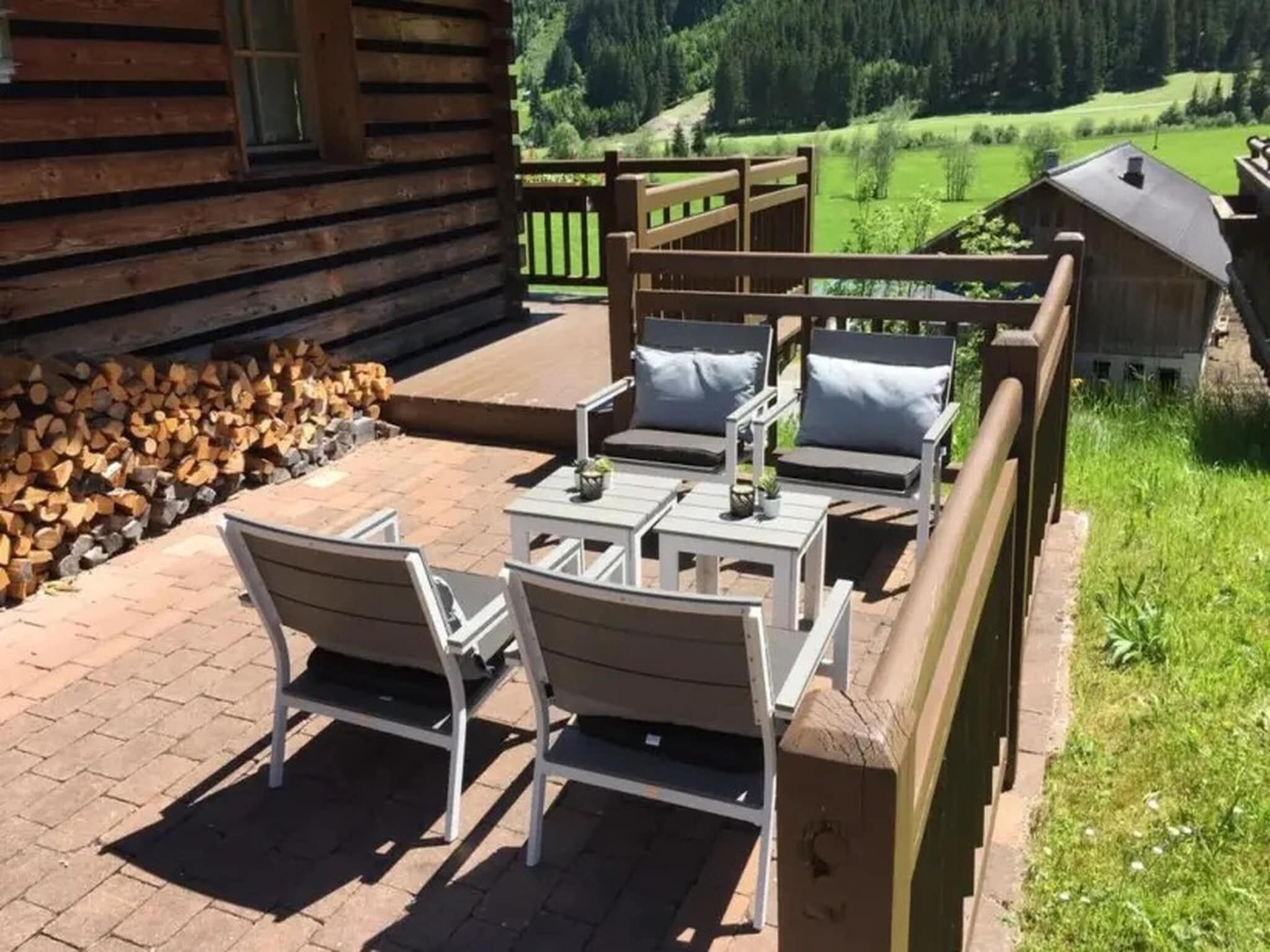 Eine Holzdiele mit einer Terrassenfläche, mit Gartenmöbeln und Blick auf die umliegende Landschaft.