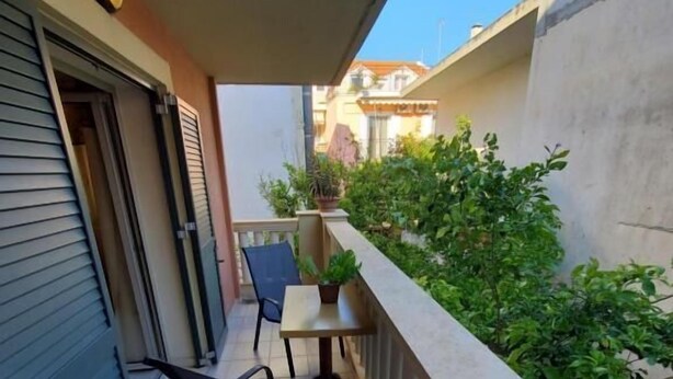 A balcony with two chairs, a small table, and potted plants.