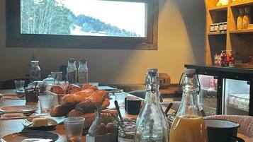Een ontbijttafel met brood, drankjes en toevoegingen.