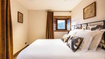 Une chambre avec un grand lit, une fenêtre avec des rideaux et un plafond en bois.