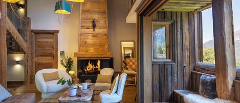 Una sala de estar acogedora con chimenea, vigas de madera y asientos cómodos.