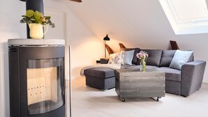 Un salon moderne avec une cheminée, un canapé, une table basse et une lampe.