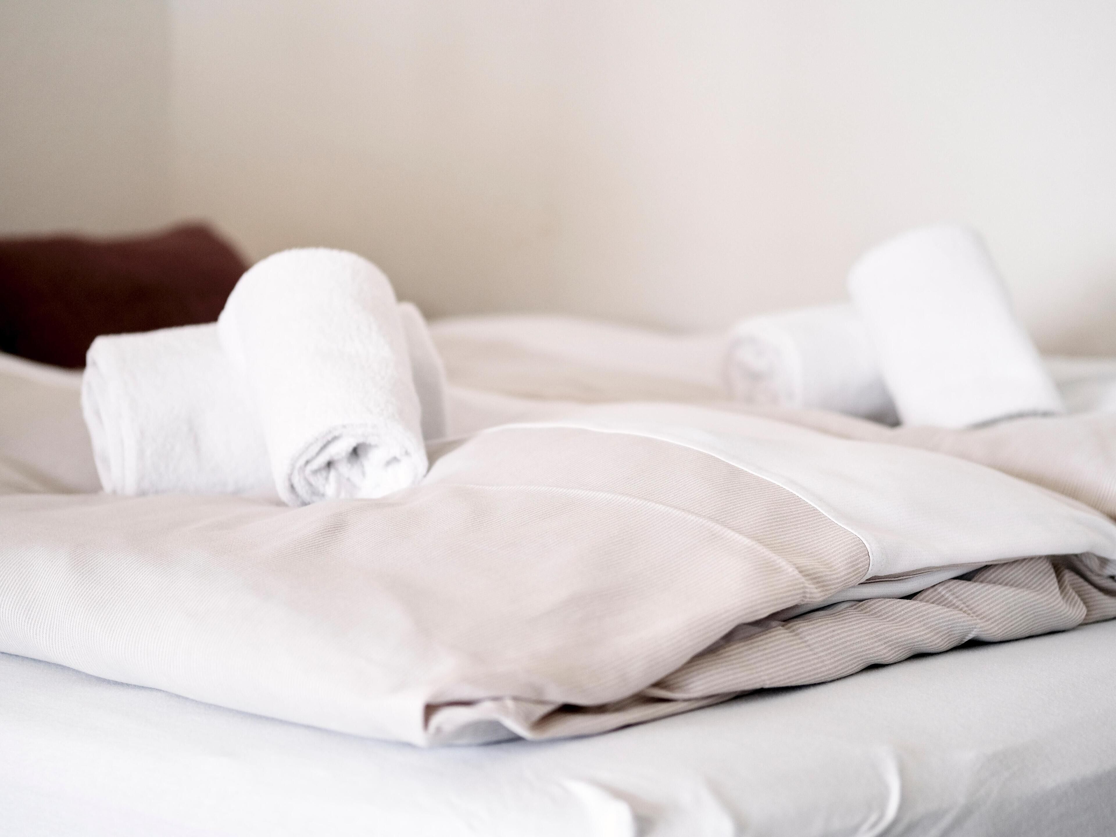 Un lit bien fait, avec du linge de lit blanc et des oreillers.