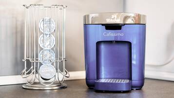 A coffee machine and a coffee cup holder with multiple cups on a countertop.