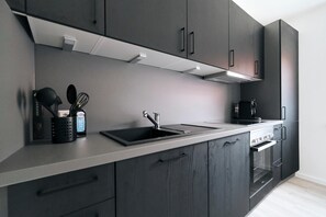 Een koelkast, een oven, een kookplaat, een koffiezetapparaat/waterkoker