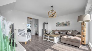 Een moderne woonkamer met een bank, salontafel en een open haard.