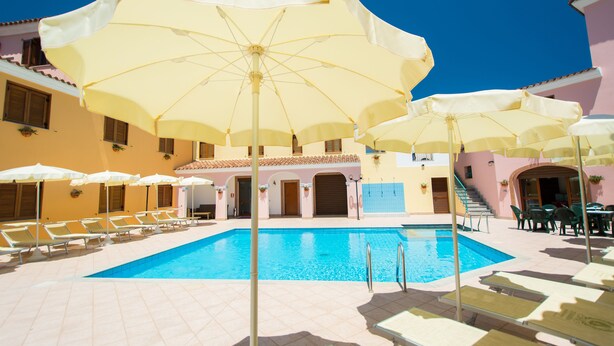 A swimming pool with sun umbrellas and lounge chairs. - Violet Residence In Orosei (Orosei)
