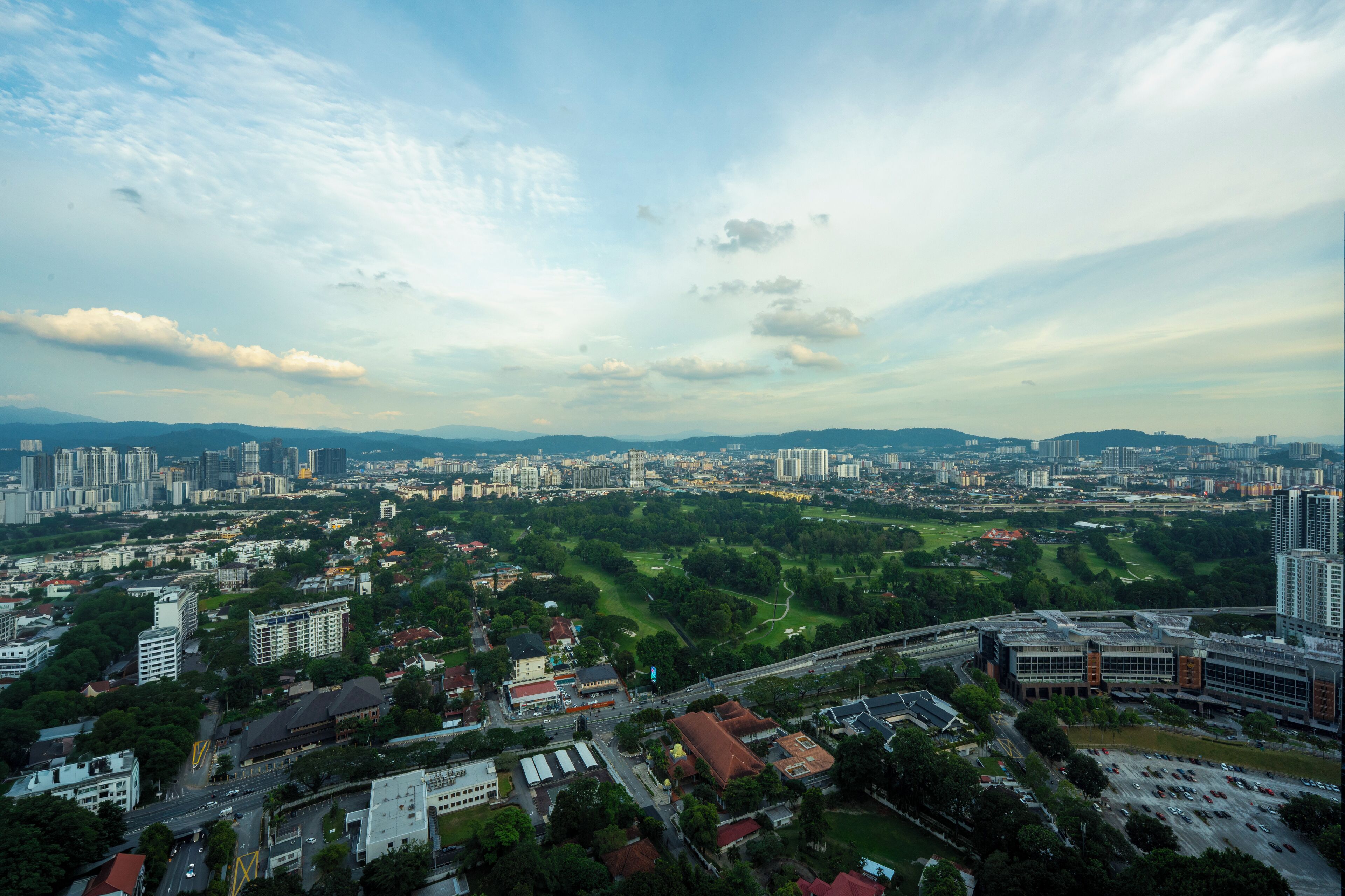 An aerial view of a city with a mix of high-rise buildings and green spaces.