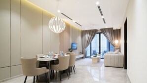 Une chambre d’hôtel moderne dotée d’un coin repas, d’un canapé et d’une télévision.