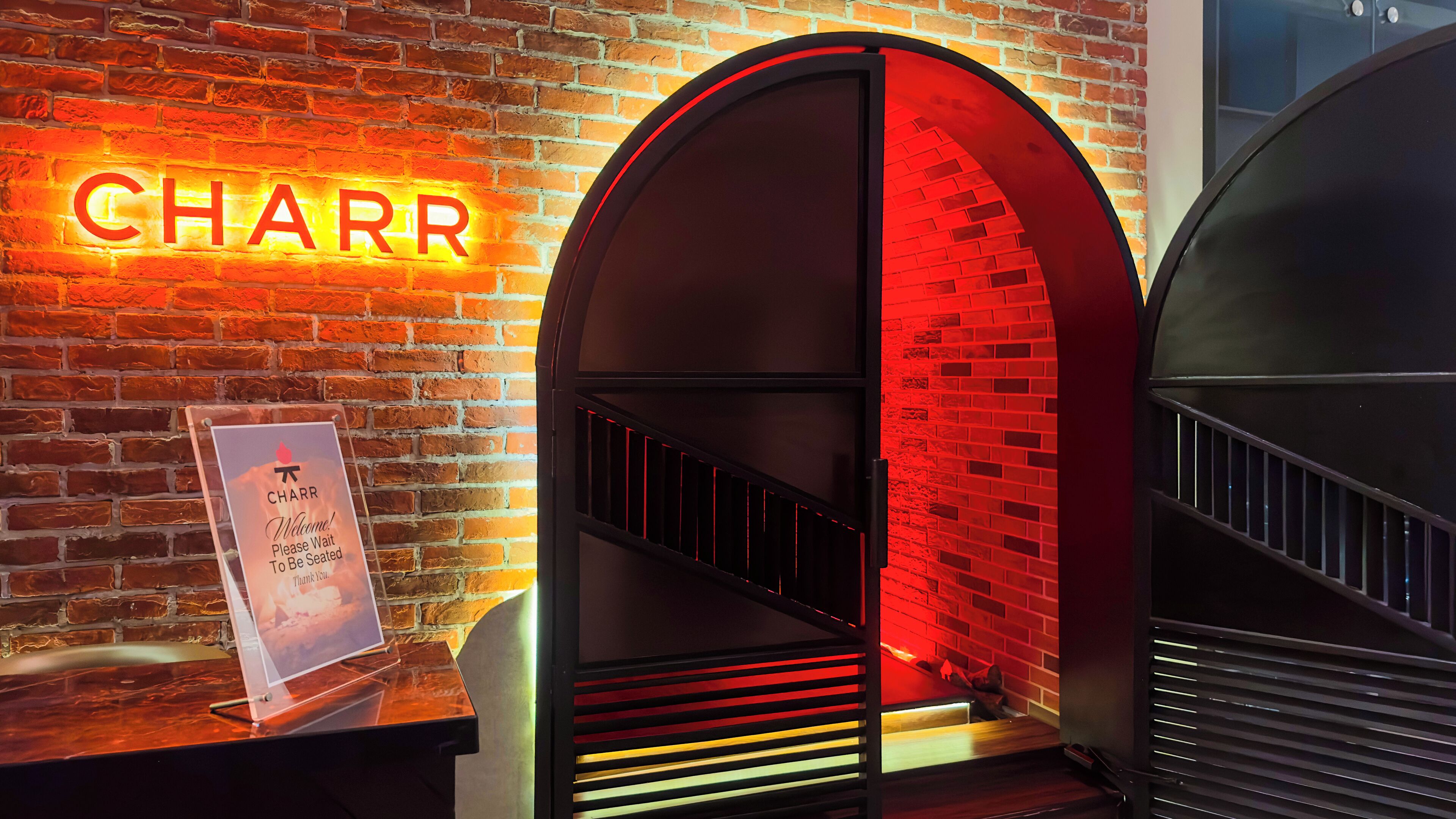 A brick wall with a neon sign reading "CHARR" and a signboard with a message.