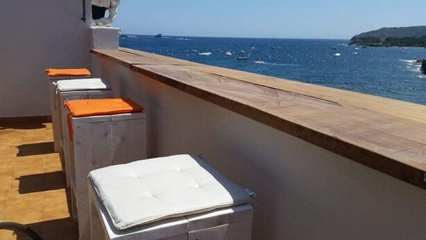 A balcony with a view of the sea and boats.