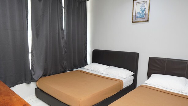 A room with two beds, a wooden desk, and a framed picture on the wall. - Hotel Sixty Nine (Johor Bahru)