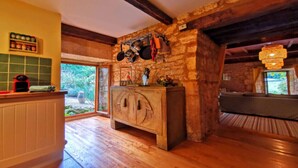 A rustic kitchen with wooden beams, a stone wall, and a wooden cabinet. - La Fermette au Banquet, Les Eyzies (Les Eyzies)