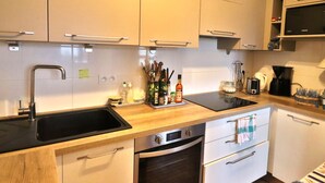 A modern kitchen with stainless steel appliances, wooden countertops, and white cabinetry. - Seafront house with garden in Groix (Groix)