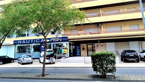 Un edifici d'edificis amb una botiga ben visible amb el rètol 'NAUTIC ASN'.