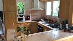 Eine Küche mit Holzausstattung, einer Mikrowelle, einer Kaffeemaschine und einem Spülbecken.