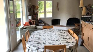 Ein gemütliches Wohnzimmer mit rundem Tisch, Kamin und Bücherregal.