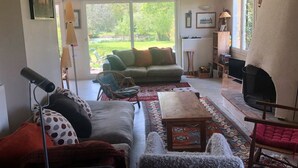 Ein gemütliches Wohnzimmer mit einer Couch, Sesseln, einem Couchtisch und einem Kamin.