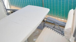 A sunbed with a metal railing, a window with a view of the sea, and a white wall. - Seaside studio with terrace, air conditioning and WIFI in Platja d'Aro (Platja d'Aro)