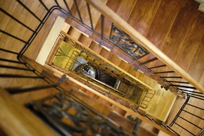 A spiral staircase with wooden steps and metal railings, leading to a lower level. - Vincent Old Town Apartments (Wroclaw)