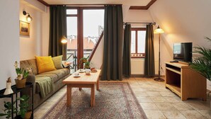A cozy living room with a sofa, coffee table, and a television on a wooden stand. - Vincent Old Town Apartments  (Wroclaw)