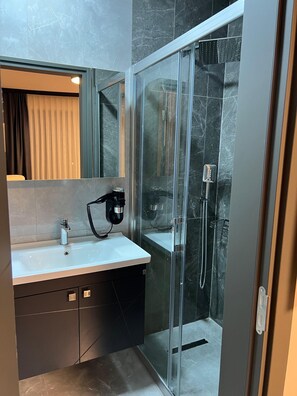 Deluxe kamer, niet-roken | Badkamer | Een douche, een haardroger, pantoffels, handdoeken