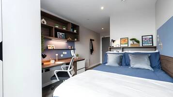 Ein modernes Schlafzimmer mit Bett, Schreibtisch und Regalelement.