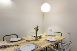Een eettafel gedekt met borden, glazen en een bloevas.
