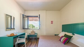 A bedroom with a bed, a desk, a chair, a window with a view, and a wardrobe. - L Ulivo Blu - One-bed 2 With Seaview Balcony -loc (Castellammare del Golfo)