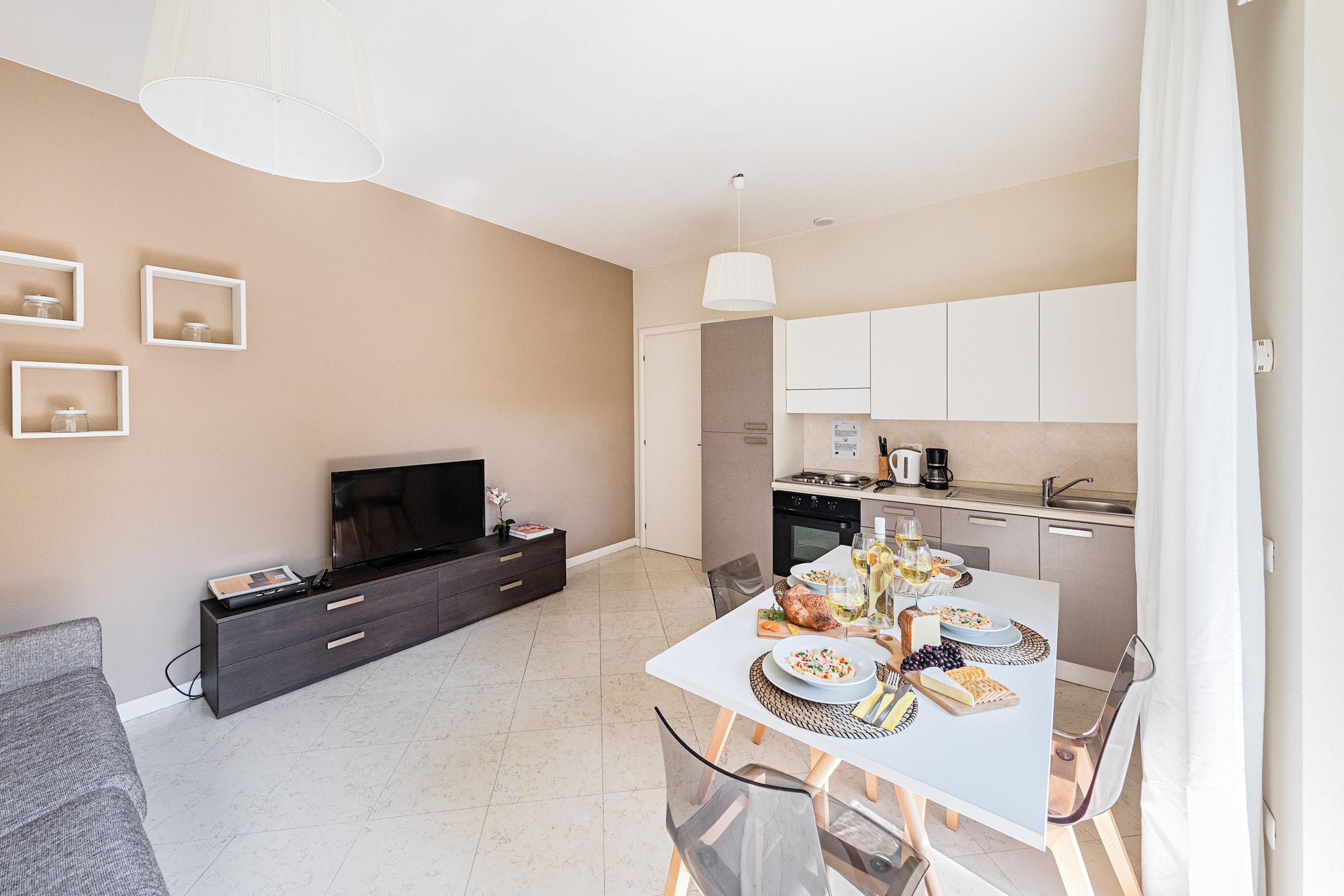 A modern apartment with a dining area, kitchen, and living space.