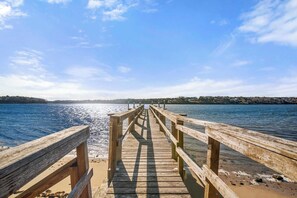 A wooden pier extending into a body of water with a clear sky above.