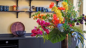A kitchen with shelves holding mugs, a teapot, and a coffee can. - Drift Hotels  (Willemstad)