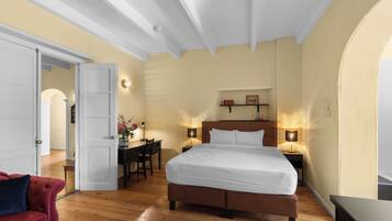 Ein Schlafzimmer mit einem großen Bett, einem Schreibtisch und zwei Nachttischlampen.