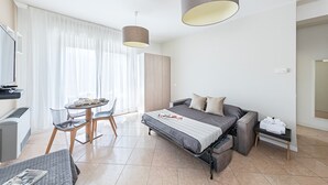 A modern hotel room with a bed, a desk, and a dining area. - Residenza Miralago - 17 Versilia - LOC BK (Desenzano del Garda)