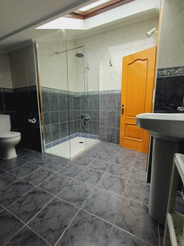Un baño con ducha, inodoro y lavabo.