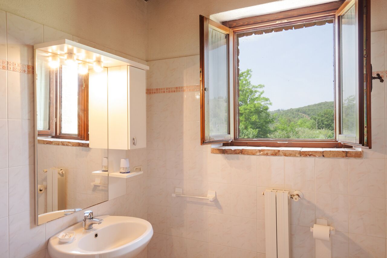 Ein Badezimmer mit Waschbecken, Spiegel und Fenster.