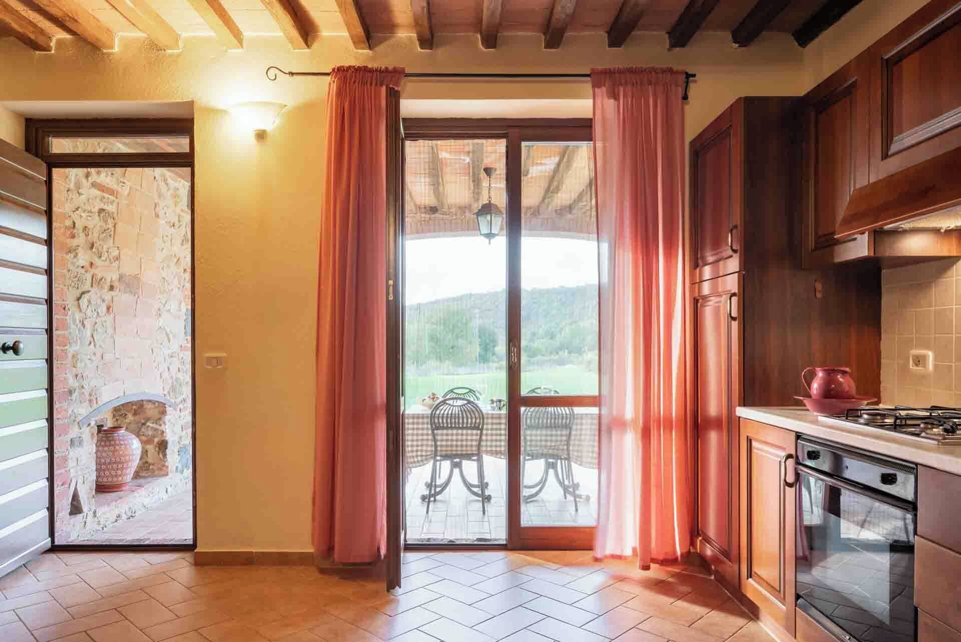 Uma cozinha com fogão, forno e um espaço de refeições com cadeiras e mesa.