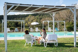 Una piscina al aire libre de temporada, sombrillas, tumbonas