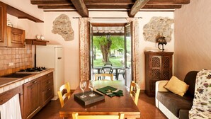 Una cocina acogedora con armarios de madera, una estufa y un comedor con mesa y sillas.