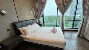 Een moderne hotelkamer met een groot bed, een nachtkastje en uitzicht op een stadsgezicht door grote ramen.