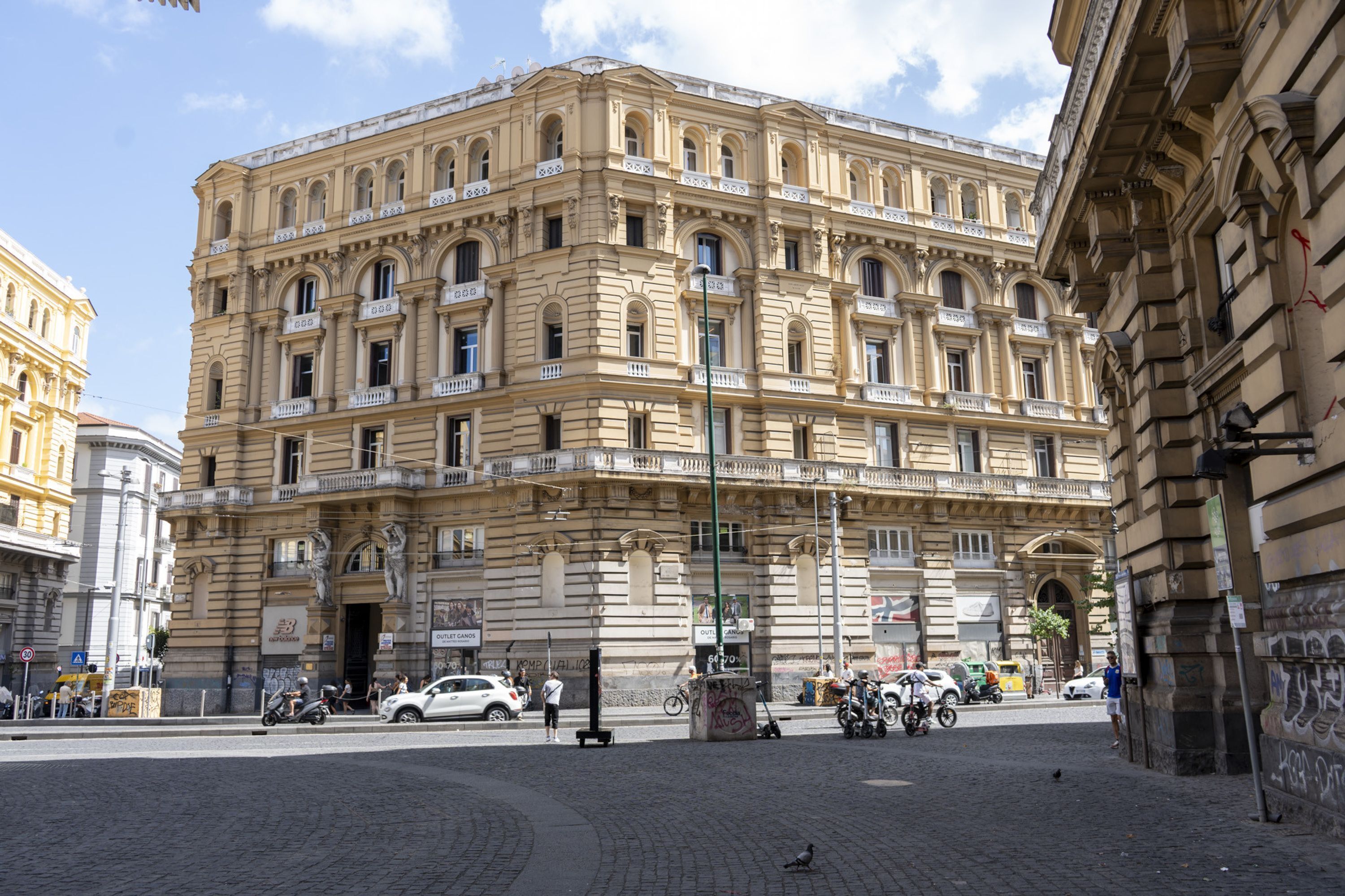 Un edificio histórico de varios pisos, con amplias ventanas y una entrada central.