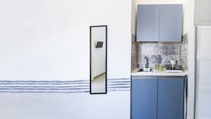 A kitchen with a blue cabinet, a white countertop, and a tiled backsplash. - Duomo 5 - Maria s Bright Flat at the Cathed w Balc (Naples)