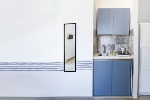 Eine Küche mit blauem Schrank, weißer Arbeitsplatte und einer gefliesten Spritzschutzwand.